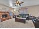 Comfortable living room featuring a brick fireplace, a ceiling fan, and ample seating at 8926 W Lockland Ct, Peoria, AZ 85382