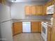 Well-lit kitchen with wooden cabinets, white appliances, and tile flooring at 10115 E Mountain View Rd # 1119, Scottsdale, AZ 85258