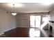 Bright living room with hardwood floors, modern light fixture, fireplace, and sliding glass doors to the outside at 10115 E Mountain View Rd # 1119, Scottsdale, AZ 85258