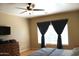 Comfortable bedroom with dark curtains, hardwood flooring, and natural light from the window at 10343 E Jacob Ave, Mesa, AZ 85209