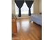 Bedroom featuring hardwood floors, a dresser, dark curtains, and natural light from the window at 10343 E Jacob Ave, Mesa, AZ 85209