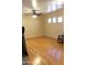 Spacious room featuring hardwood flooring, a ceiling fan, and natural light from the windows at 10343 E Jacob Ave, Mesa, AZ 85209