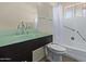 Bathroom featuring a sleek glass countertop vanity and a shower-tub combo with a white shower curtain at 10846 W Sun City Blvd, Sun City, AZ 85351