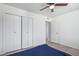 Bedroom with gray wood-look floors, white walls, a ceiling fan, and a double-door closet at 10846 W Sun City Blvd, Sun City, AZ 85351