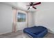 Bedroom featuring gray wood-look floors, white walls, a ceiling fan, and natural light at 10846 W Sun City Blvd, Sun City, AZ 85351