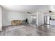 Open-concept living room features gray wood-look floors, a ceiling fan, and brick accent wall at 10846 W Sun City Blvd, Sun City, AZ 85351