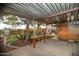 Covered patio with a wooden table surrounded by mature trees at 1261 E Edgemont Ave, Phoenix, AZ 85006