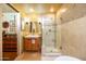 Well-lit bathroom with wood vanity, stylish mirror, and tiled walk-in shower at 1261 E Edgemont Ave, Phoenix, AZ 85006