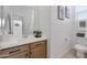 Bright bathroom featuring a wood vanity, white countertops, and decorative wall art at 14254 W Cottontail Ln, Surprise, AZ 85387