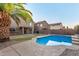 A refreshing backyard pool surrounded by green grass and view of the house at 15466 W Shangri La Rd, Surprise, AZ 85379