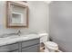 Cozy half bathroom with gray vanity, granite countertop, and decorative mirror at 15466 W Shangri La Rd, Surprise, AZ 85379