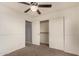 This bedroom has a ceiling fan, sliding closet doors, carpet, and a doorway to another area at 15466 W Shangri La Rd, Surprise, AZ 85379