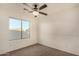 This bedroom features a ceiling fan, carpet, and a window that provides natural light at 15466 W Shangri La Rd, Surprise, AZ 85379