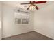 This bedroom features a ceiling fan, a window, and neutral carpet flooring at 15466 W Shangri La Rd, Surprise, AZ 85379