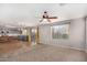 Open living room with carpet, ceiling fan, and view into the kitchen and backyard at 15466 W Shangri La Rd, Surprise, AZ 85379