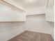 Spacious walk-in closet with carpet flooring and plenty of wooden shelves and hanging rods at 15466 W Shangri La Rd, Surprise, AZ 85379