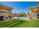 Outdoor living space with manicured lawn, pergola, and sparkling pool, perfect for entertaining at 16993 W Shiloh Ave, Goodyear, AZ 85338