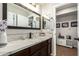 A modern bathroom vanity featuring a stone countertop, dark cabinets and mirrors at 16993 W Shiloh Ave, Goodyear, AZ 85338