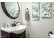 Powder room featuring modern fixtures, granite countertop, and decorative artwork at 16993 W Shiloh Ave, Goodyear, AZ 85338