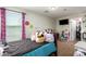 A delightful bedroom with a bed adorned with plush toys, a window, and closet access at 16993 W Shiloh Ave, Goodyear, AZ 85338