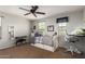 A well-lit bedroom featuring a bed, a desk, and a ceiling fan at 16993 W Shiloh Ave, Goodyear, AZ 85338