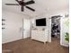 Cozy bedroom featuring carpet, ceiling fan, dresser, and a walk-in closet for ample storage at 16993 W Shiloh Ave, Goodyear, AZ 85338