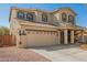 Two-story home with desert landscaping, a charming front porch swing, and a two-car garage at 16993 W Shiloh Ave, Goodyear, AZ 85338