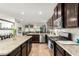 Spacious kitchen with dark wood cabinets, granite countertops, and stainless steel appliances at 16993 W Shiloh Ave, Goodyear, AZ 85338