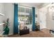 Bright living room with ample natural light, teal curtains, and a small aquarium on a stand at 16993 W Shiloh Ave, Goodyear, AZ 85338