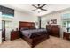 Primary bedroom with an expansive wood bed frame, ceiling fan, and stylish decor at 16993 W Shiloh Ave, Goodyear, AZ 85338