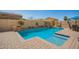 Inviting pool with brick surround and lush landscaping offers a serene backyard retreat at 16993 W Shiloh Ave, Goodyear, AZ 85338