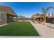 Beautiful backyard featuring a well-kept lawn, cozy pergola, and desert landscaping at 1781 S 223Rd Dr, Buckeye, AZ 85326