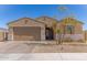 Inviting home exterior with a two-car garage, desert landscaping, and a well-maintained lawn at 1781 S 223Rd Dr, Buckeye, AZ 85326