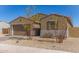 Home exterior featuring a two-car garage, desert landscaping, and manicured shrubs at 1781 S 223Rd Dr, Buckeye, AZ 85326