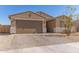 Charming single-story home with a two-car garage, desert landscaping, and a paved driveway at 1781 S 223Rd Dr, Buckeye, AZ 85326