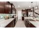 Kitchen featuring dark wood cabinets, stainless steel appliances, and granite countertops at 1781 S 223Rd Dr, Buckeye, AZ 85326