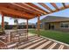 Backyard pergola with seating, adjacent to green lawn, perfect for outdoor relaxation at 1781 S 223Rd Dr, Buckeye, AZ 85326