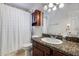 Bathroom with a granite vanity top, modern lighting, and a shower with a white shower curtain at 1837 E Coolidge St, Phoenix, AZ 85016