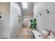 Inviting hallway with a skylight, coat hooks, white bench, and a fiddle-leaf fig plant at 1837 E Coolidge St, Phoenix, AZ 85016