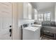 Clean and bright laundry room with white cabinets, modern appliances, and a utility sink at 1837 E Coolidge St, Phoenix, AZ 85016