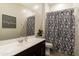 Bathroom features a large mirror, shower with patterned curtain, and modern vanity at 18501 W Galveston St, Goodyear, AZ 85338