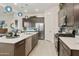 Well-lit kitchen with stainless appliances, island with seating, and a decorative backsplash at 18501 W Galveston St, Goodyear, AZ 85338