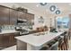 Well-lit kitchen with stainless appliances, island with seating, and a decorative backsplash at 18501 W Galveston St, Goodyear, AZ 85338