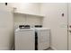 Clean laundry room with modern washer and dryer, and a convenient shelf at 18501 W Galveston St, Goodyear, AZ 85338