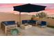 Enjoy outdoor living on the patio with comfortable seating, umbrella and a cozy fire pit at 18501 W Galveston St, Goodyear, AZ 85338