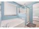 Bathroom featuring a bathtub, walk-in shower and serene light-blue walls at 19259 N Ventana Ln, Maricopa, AZ 85138