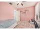 Pink bedroom featuring light wood flooring, a patterned bedspread, shelves, and bright natural light at 19259 N Ventana Ln, Maricopa, AZ 85138