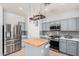 Modern kitchen featuring stainless steel appliances, gray cabinets, butcher block island, and tiled backsplash at 19259 N Ventana Ln, Maricopa, AZ 85138