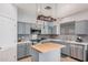 Well-lit kitchen with stainless steel appliances, gray cabinets, butcher block island, and tiled backsplash at 19259 N Ventana Ln, Maricopa, AZ 85138