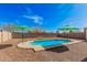 Backyard swimming pool in a gravel yard featuring lounging chairs and patio umbrellas at 19259 N Ventana Ln, Maricopa, AZ 85138